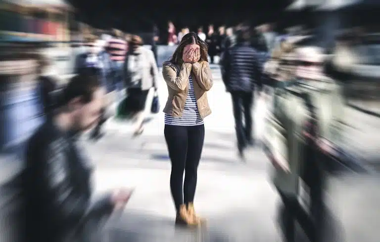 A woman suffers from anxiety in the midst of a busy crowd