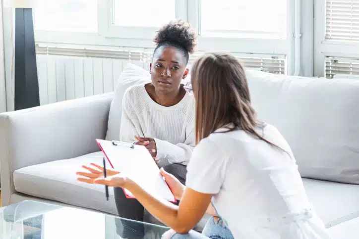 A psychiatrist consults with her depressed patient about starting TMS treatment for depression