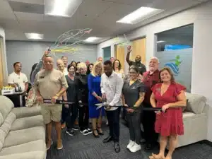 The crowd watches as Kyle Hartfield cuts the ribbon to open the new Murrieta psychiatry clinic of Inland Empire TMS